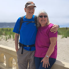 A person and person standing on a bridge
Description automatically generated